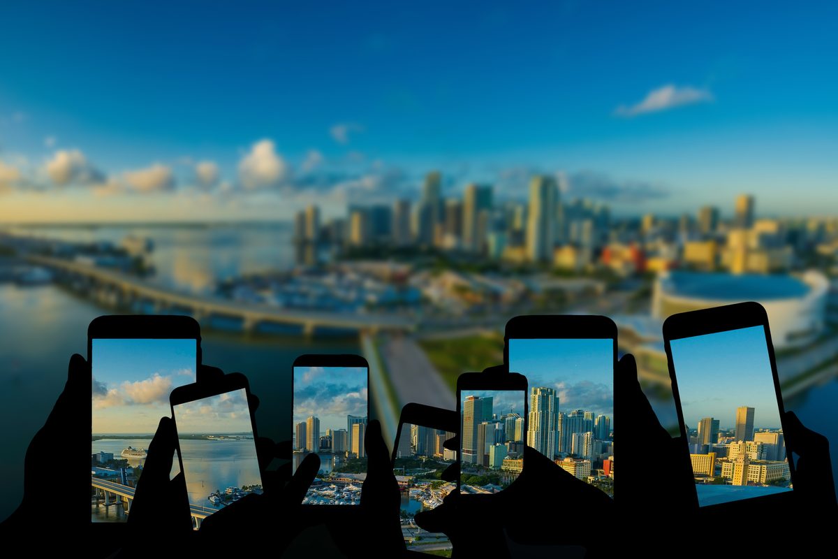 複数のスマートフォン越しに都市の風景を見る人々